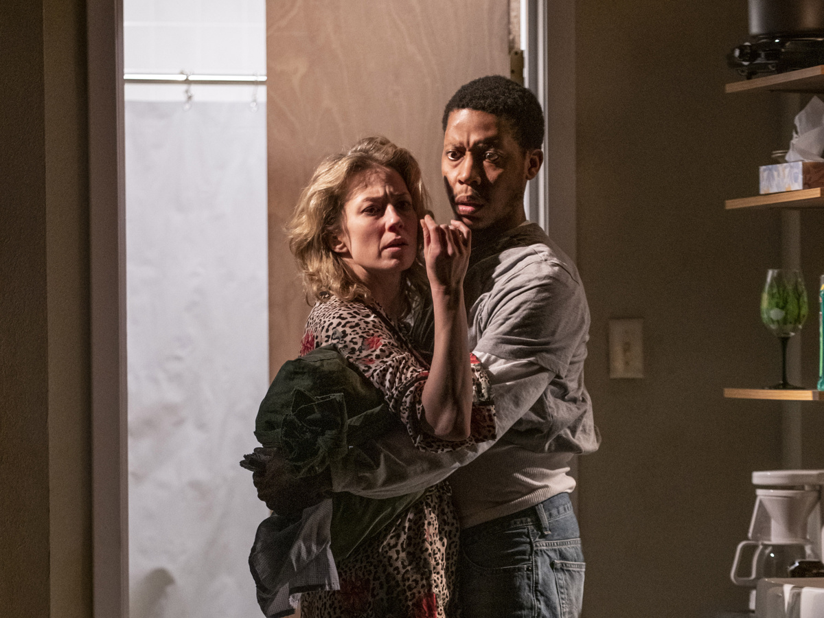 Carrie Coon and Namir Smallwood look distressed while holding one another in Bug