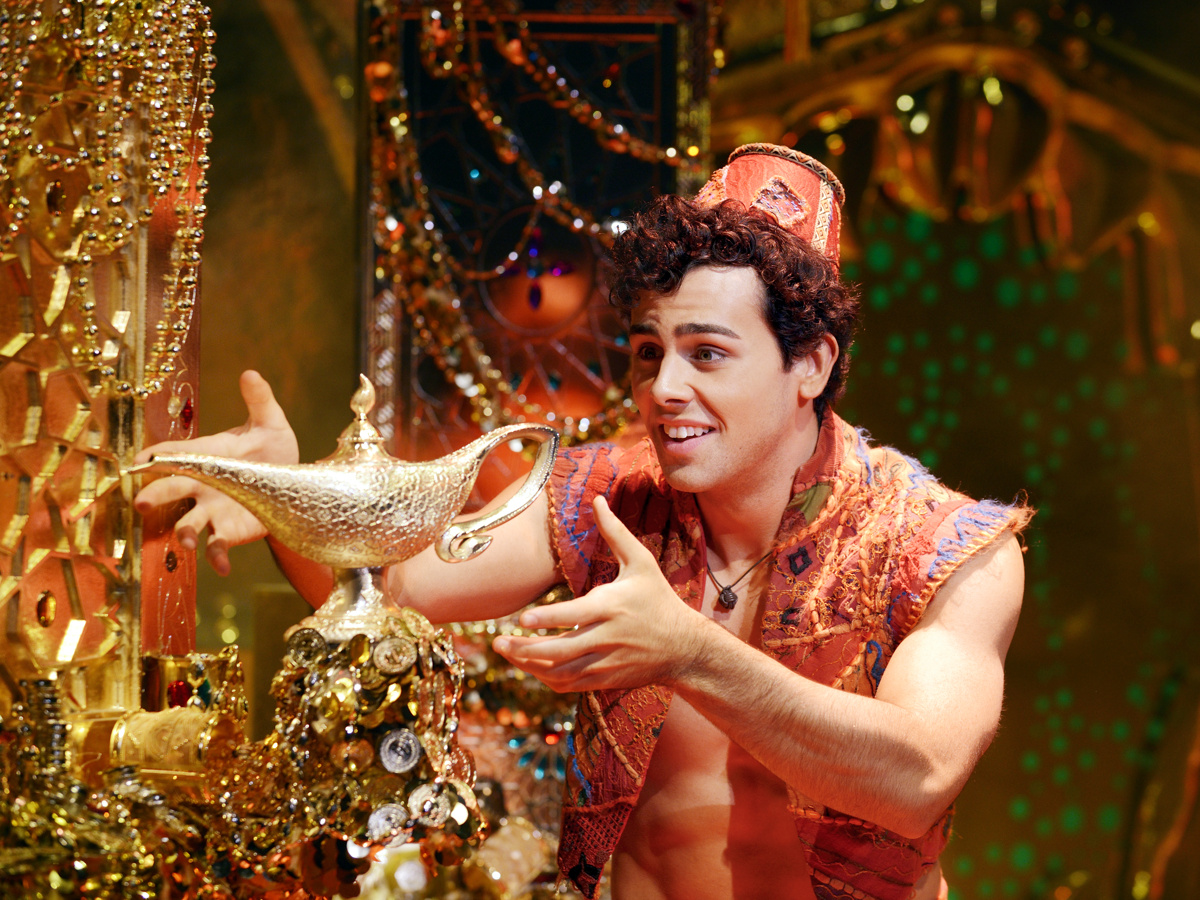 Ainsley Melham as Aladdin holds the magic lamp in Aladdin on Broadway